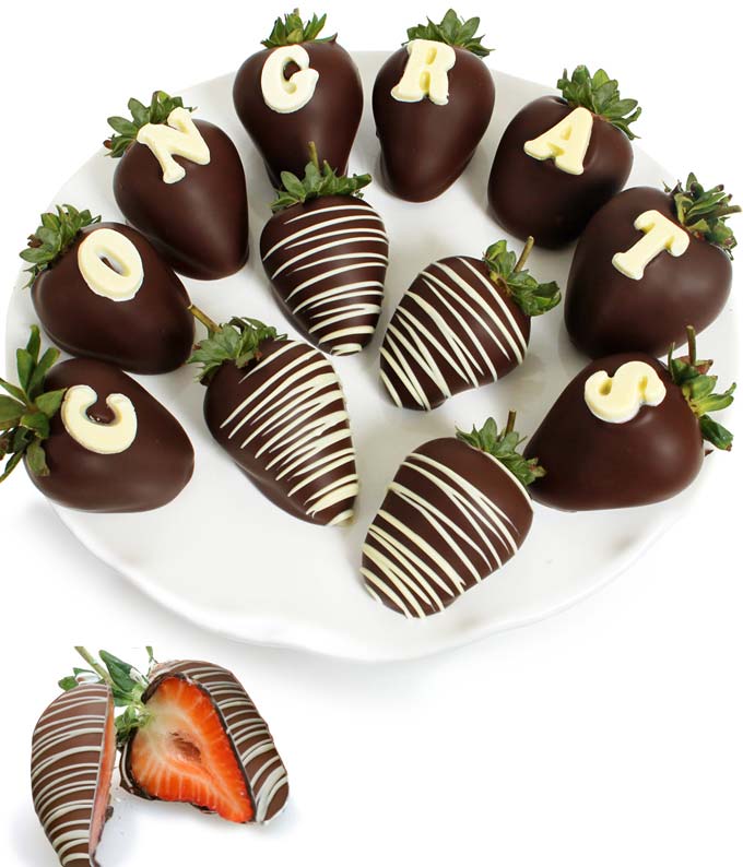 Strawberries dipped in chocolate with white chocolate that says 'Congrats'
