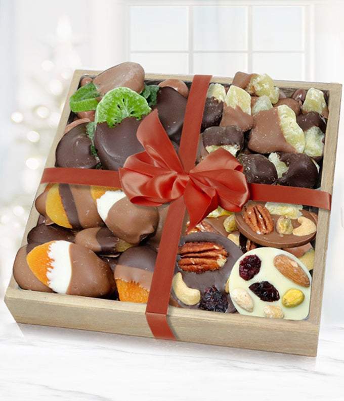 Chocolate covered dried apricots, kiwi and pineapple delivered with dried nuts in a wooden tray